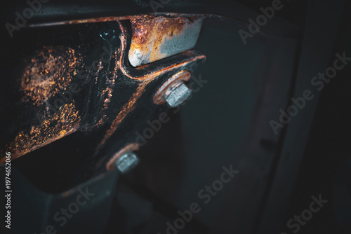 a car suspension component, experiencing significant surface rust and corrosion around the attachment bolts. automotive background with copy space