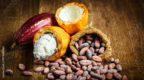 Tableau sur toile Cocoa bean in sack and fresh cacao pods on rustic wooden background, Close-up