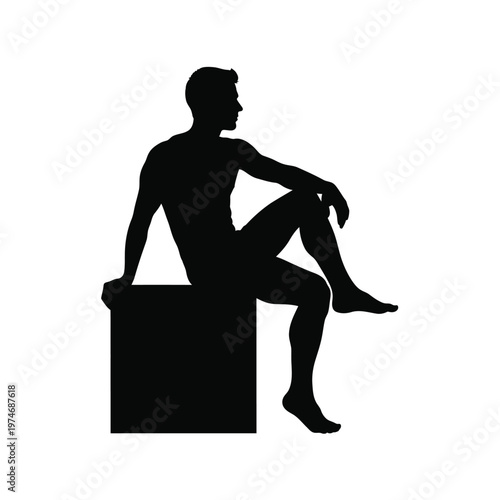 Silhouette of a man sitting relaxed on a block with one leg raised