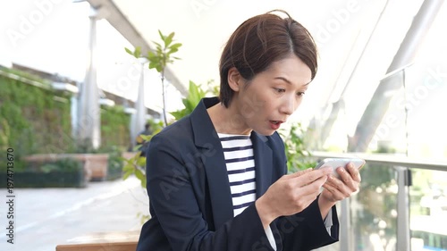 Japanese Businesswoman Overjoyed at Smartphone Screen Outdoors, Elated Reaction, Static Shot