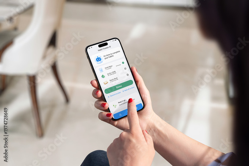 Woman using habit tracker app on smartphone, building daily routines and productivity habits in modern indoor lifestyle setting