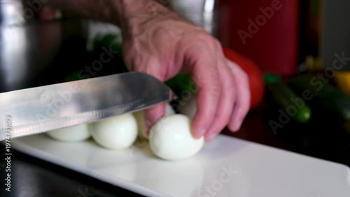 A male hand picks up boiled chicken eggs from the table as the camera glides through them. Dolly slider, close-up.