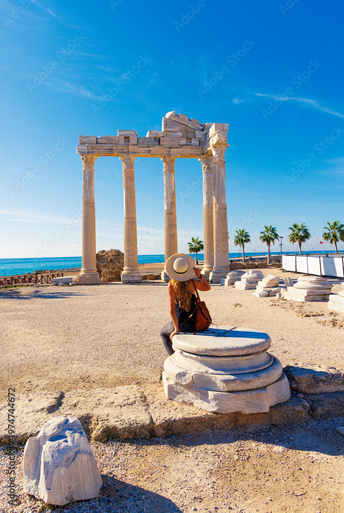 Obraz premium Female tourist looking at the Temple of Apollo by the sea in Side, Turkey