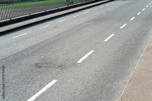 Asphalt road with white dashed lines and guard rail