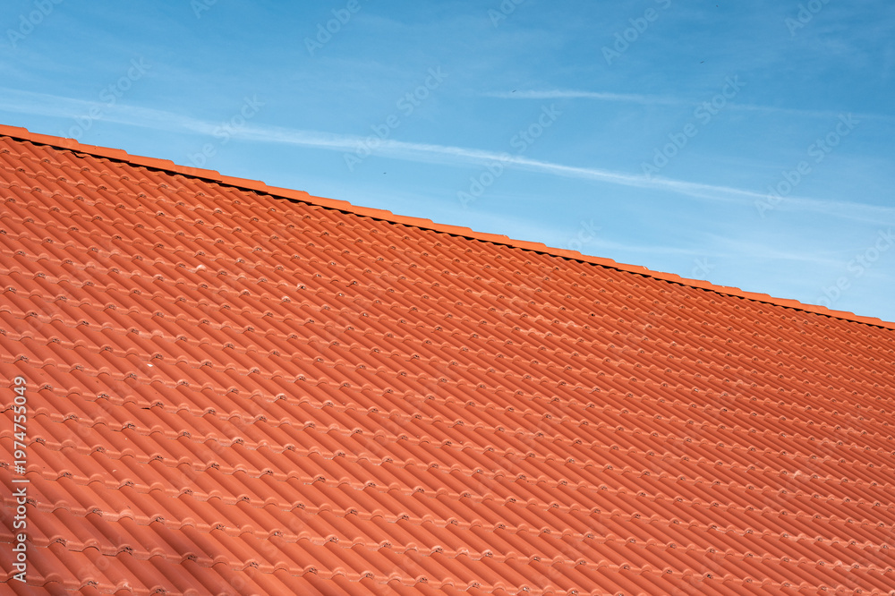 Fototapeta premium Red clay tile roof against clear blue sky