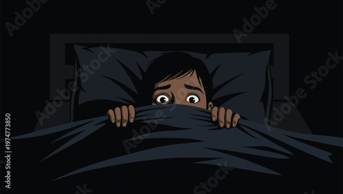 Young boy hiding under a dark blanket in bed with wide eyes looking scared of the dark and nightmares in a spooky atmosphere.
