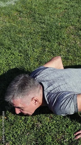 54-year-old Man Workout on Grass Field. Athletic Middle Aged Man Doing Pushups Outdoors. Series Track Code: Fit-Mature-Man-54-Outdoor-Fitness-Series-2024
