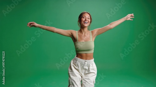 Joyful Expression: A radiant individual, dressed in casual attire, spreads their arms wide, embodying a sense of freedom and boundless joy against the vivid green background.