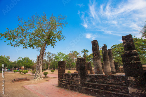 Ancient stone pillars ,columns at Sukhothai province Thailand, stand tall against a clear blue sky. Weathered columns exhibit showcasing historical architecture.