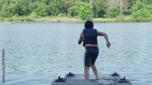 Wallpaper Mural A young adventurous boy jumps off a pier into a lake. Torontodigital.ca