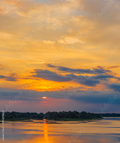 Pano landscape with sunset and colorful clouds reflecting in the water