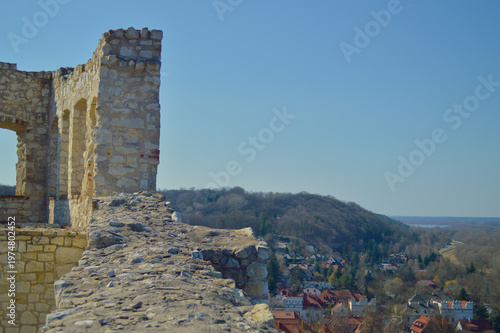 Ancient stone castle ruins in Kazimierz Dolny overlooking the picturesque old town and Vistula river valley in Poland under a bright clear blue sky during a sunny day