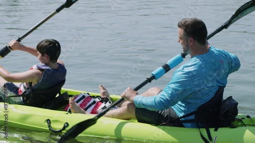 Wallpaper Mural A father and his son paddle a kayak across some calm water. Torontodigital.ca