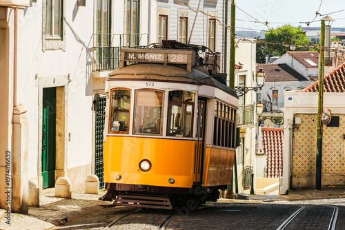 Yellow Tram 28 in Historic Neighborhood Alfama on Sunny Day. Lisbon, Portugal