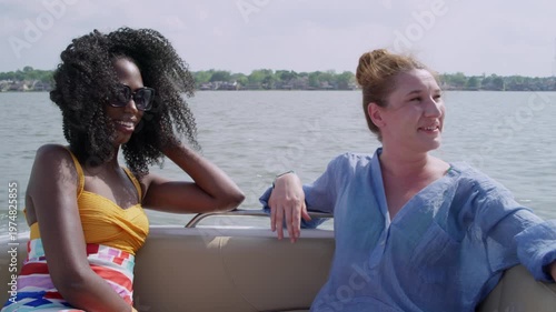 Wallpaper Mural Two women talk and laugh on a boat as it speeds through the water. Torontodigital.ca