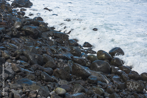 Basalt boulders and surf on Madeira's rugged volcanic pebble shore