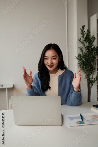 Young Asian woman gesturing during online video call