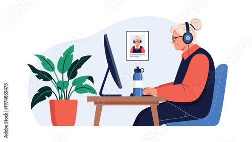 Senior woman wearing headphones while working efficiently at her home office desk equipped with a computer and a plant.