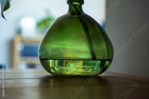 Foto Green glass bottle base on wooden table in Madeira home interior