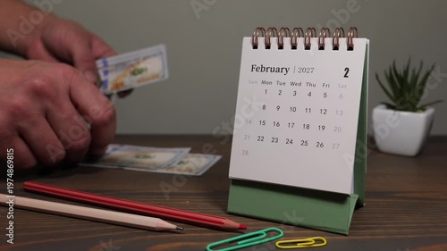 February 2027 Calendar With Credit Card Payment Planning on Desk