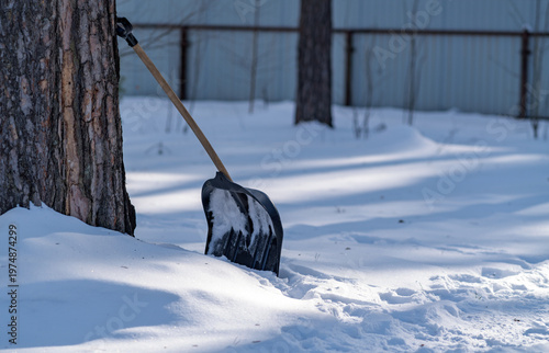 A snow shovel stuck into the snow.