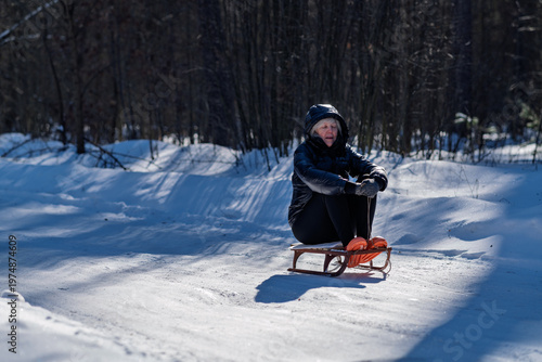 A woman sits alone on a sled.