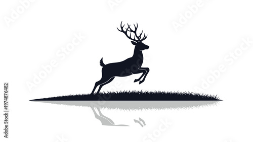 Elegant black silhouette of a male deer with large antlers jumping over a grassy field with a reflection on water.