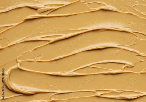 Thick layer of smooth, creamy peanut butter texture forming an appetizing food background. Ideal backdrop for bakery, snack, or breakfast designs, organic, oily, abstract