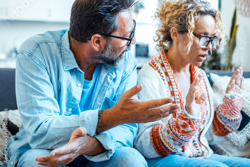 Couple arguing on couch at home during a tense relationship discussion about communication and boundaries