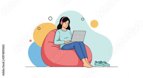 Young woman wearing headphones sitting comfortably in a red bean bag chair and working on her silver laptop at home.