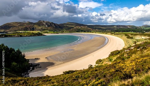 Scenic coastal panorama reveals a crescent beach bordered by grassy hills under a dramatic sky