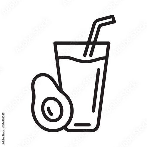 A glass of beverage with a straw and a sliced avocado nearby