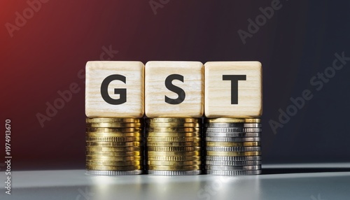 Wooden blocks with the letters gst on stacks of coins against a dark background
