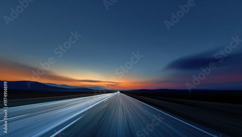 Endless highway into a blurry, colorful sunset with mountains