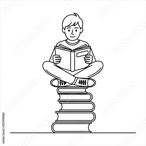 Young boy sitting cross legged on stack of books and reading