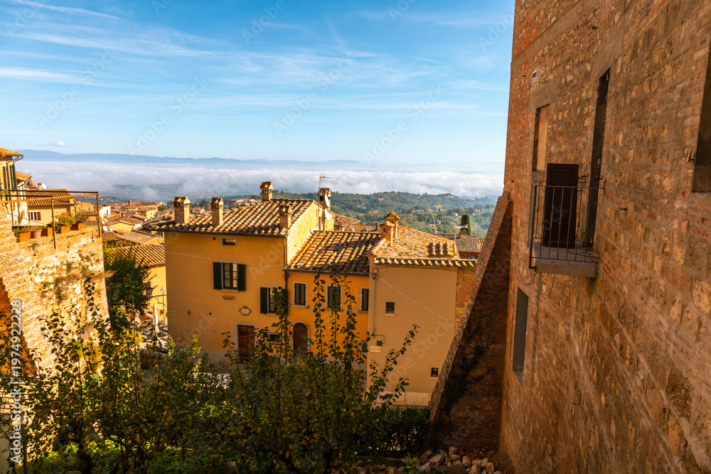 Fototapeta premium Montepulciano rooftops over foggy Val d'Orcia valley, Italy.