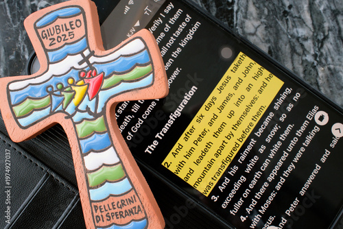 Tableau sur toile Jubilee 2025 cross beside smartphone displaying Bible app with Transfiguration passage highlighted
