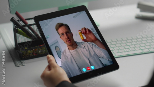 Closeup unknown patient videocall doctor using tablet at workplace. Man talking