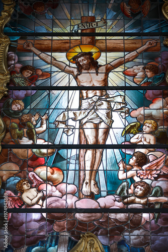 Oliwa cathedral.  Church stained glass showing Christ on the cross surrounded by cherubs and clouds. Crucifixion.  Gdansk. Poland.