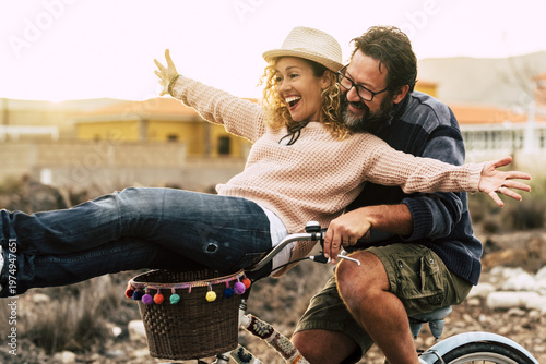 Bild auf Leinwand Happy couple riding a bicycle together, playful summer romance and joyful outdoo