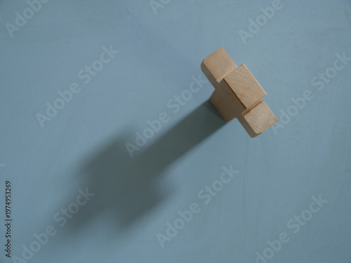 A wooden cross casts a shadow, still life