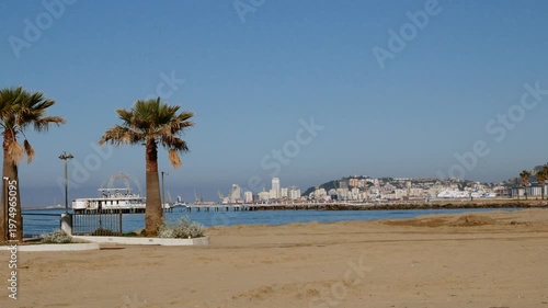 Stunning beachfront view with palm trees, pier, and city skyline in Albania, perfect for vacation, tourism, and travel destinations.