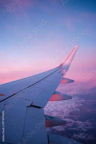Canvas Print Airplane wing during sunset above clouds