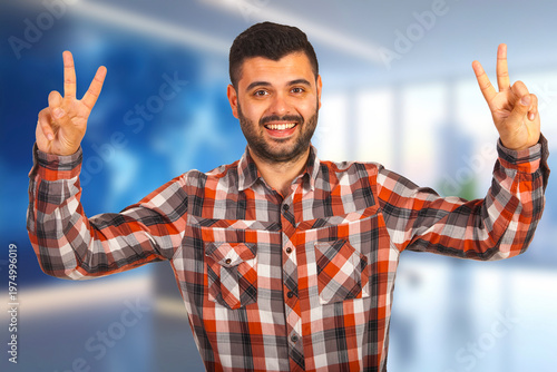 Young man smiles, showing two peace signs