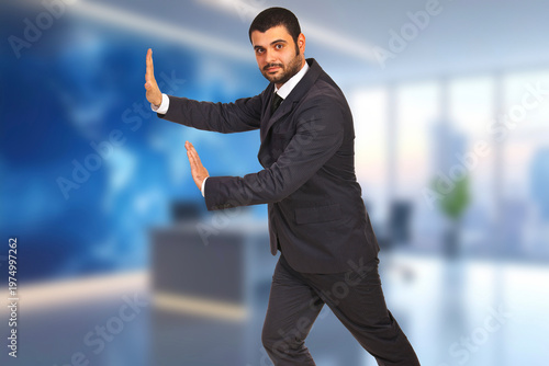 Man in suit stands confidently with hands raised