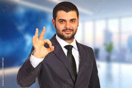 Confident man gestures approval in professional office setting