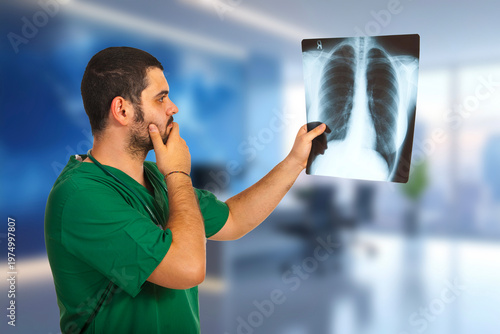 Doctor holds chest X-ray with focused expression