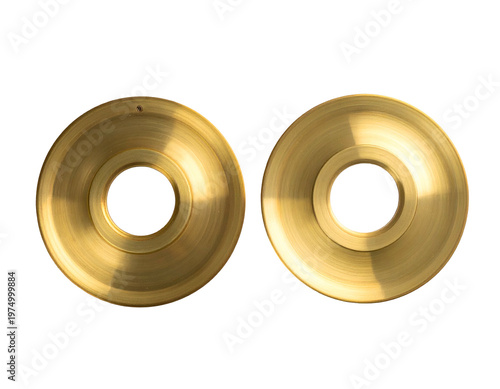 Two circular brass-toned metal discs with concentric rings, on black