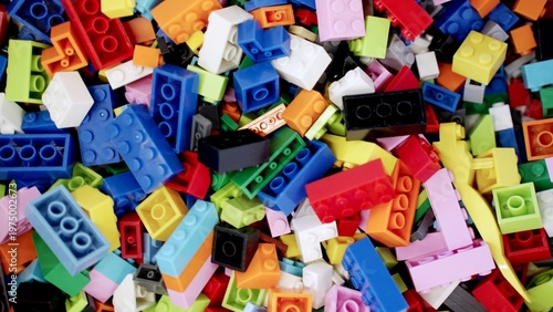 Close up of pile of multi-colored plastic block toys that can be arranged into various shapes. Top view. Slow motion. Game center concept