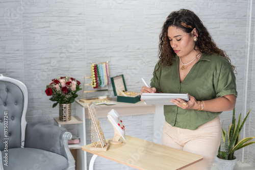 Female entrepreneur managing jewelry business using tablet